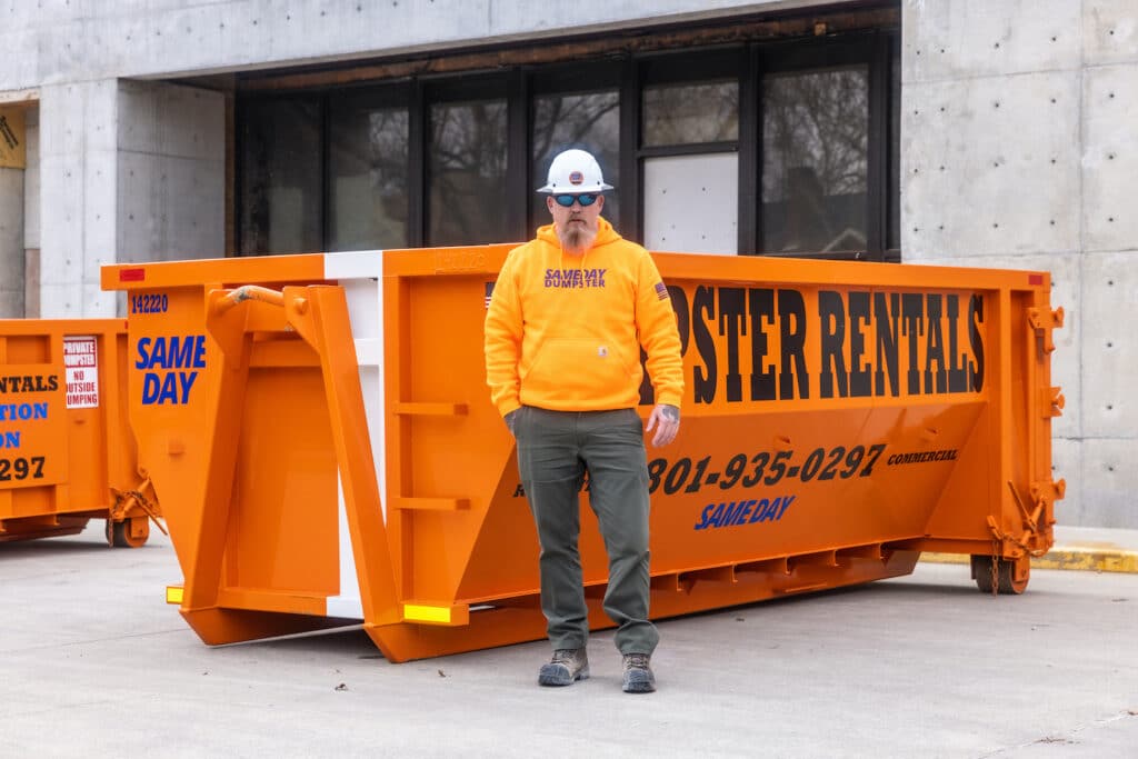 A man standing in front of a 17 yard dumpster provided by Sameday Dumpster
