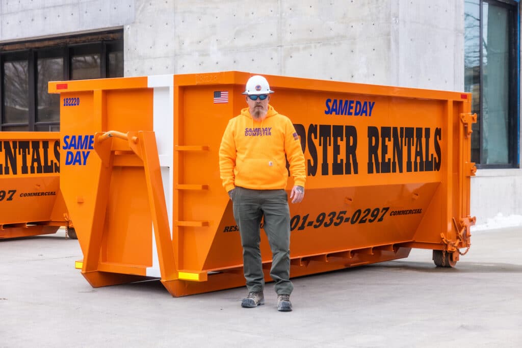 A man standing in front of a 22 yard dumpster provided by Sameday Dumpster