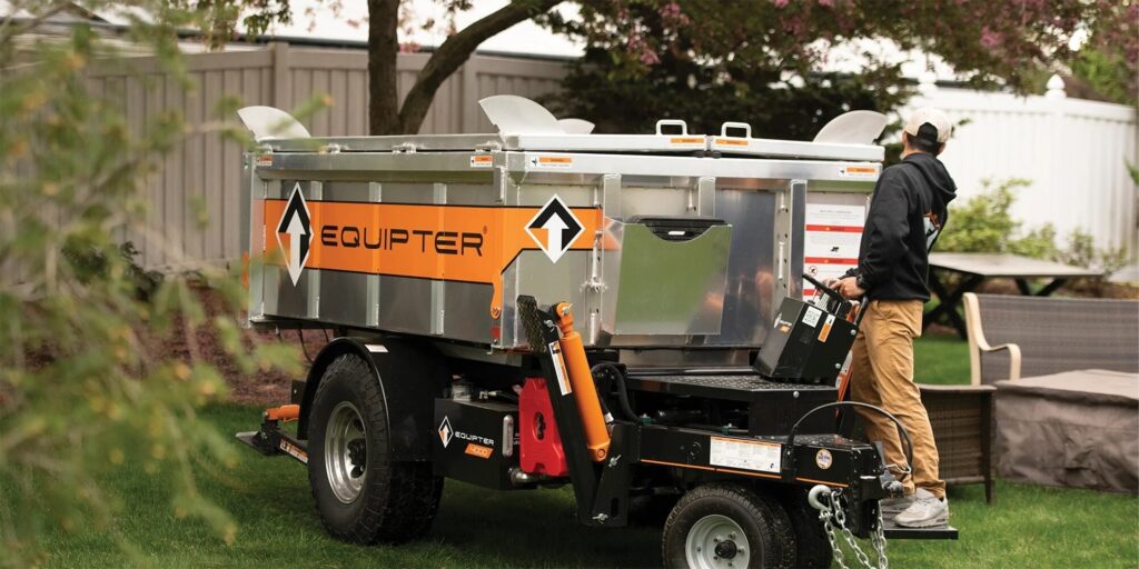 A man standing in front of a 12 yard dumpster provided by Sameday Dumpster
